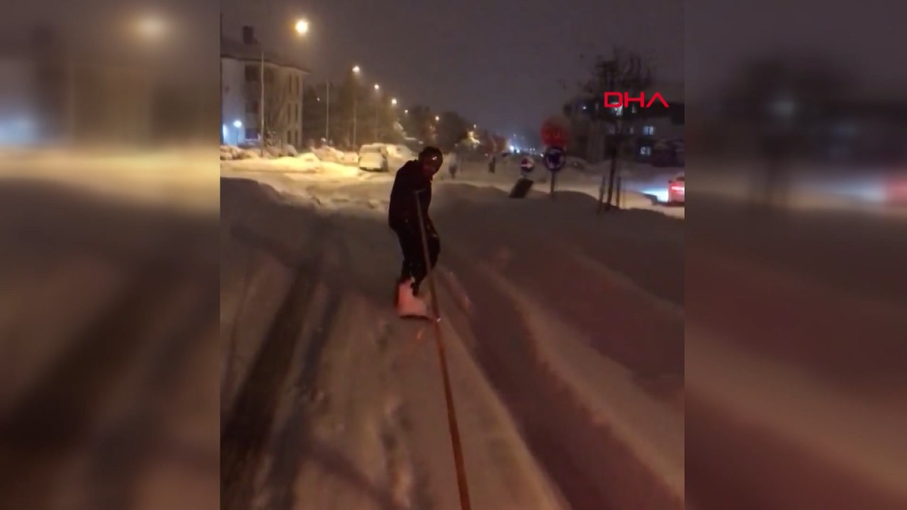 Karlı sokaklarda snowboard yaptı