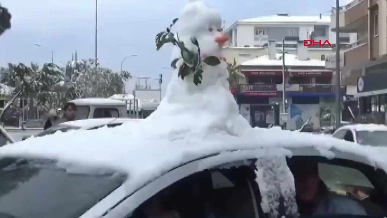 Yaptığı kardan adamı otomobilin üzerinde gezdirdi